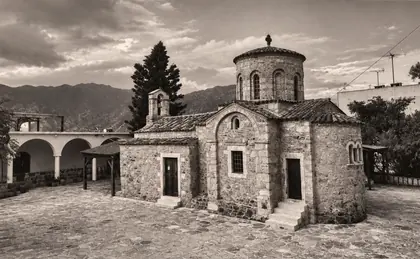 Φωτογραφία: πέτρινο βυζαντινό εκκλησάκι με βουνά στο βάθος